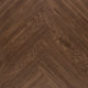 Detail van visgraat klik pvc vloer donkerbruin eiken met voelbare houtstructuur